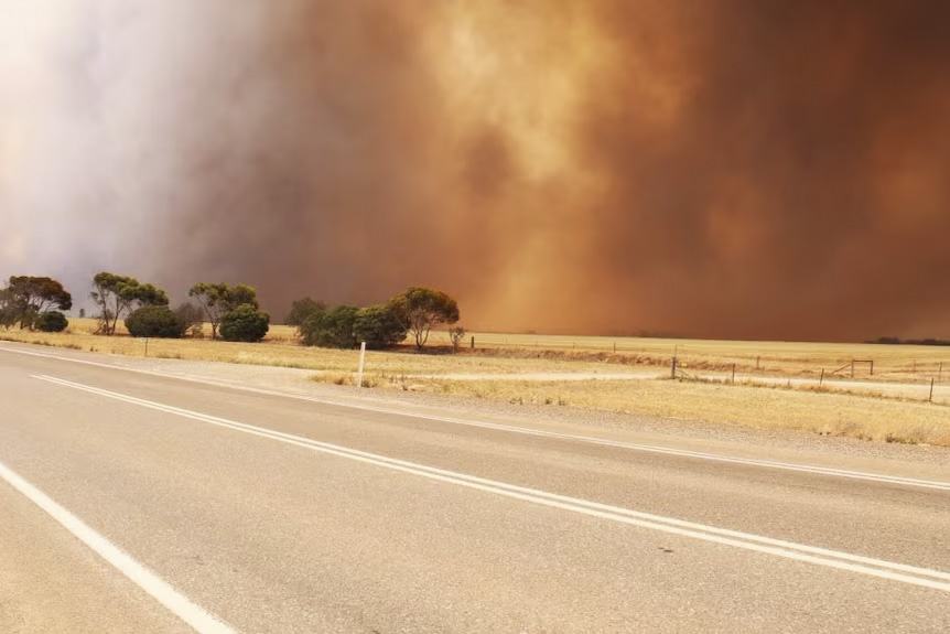 Orange smoke in the distance on a regional Victorian road